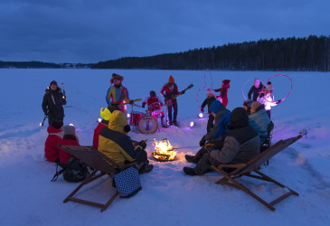 Ihmisiä iltanuotiolla talvella.