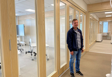 Mies lasiseinän edessä.
