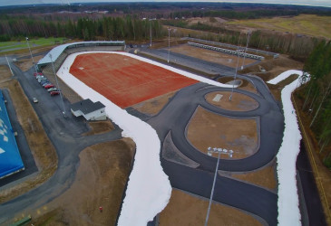 ilmakuva, jossa latu kiertää lumettomalla stadionilla.