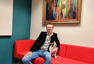 Timo Rissanen sohvalla koiransa kanssa