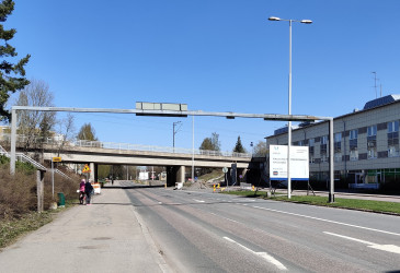 tiettä, silta ja kaksi ihmistä bussipysäkillä.