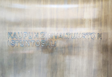 Valtuustosalin ovi. Ovessa lukee Kaupunginvaltuuston istuntosali.