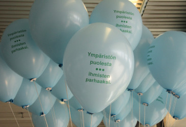 Ilmapalloja sisätilassa. Palloissa teksti Ympäristön puolesta, ihmisten parhaaksi.