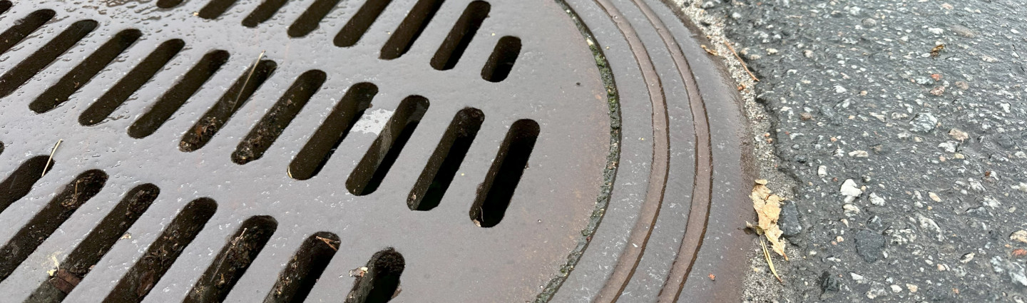 Lähikuva kaivon kannesta sateisella säällä.