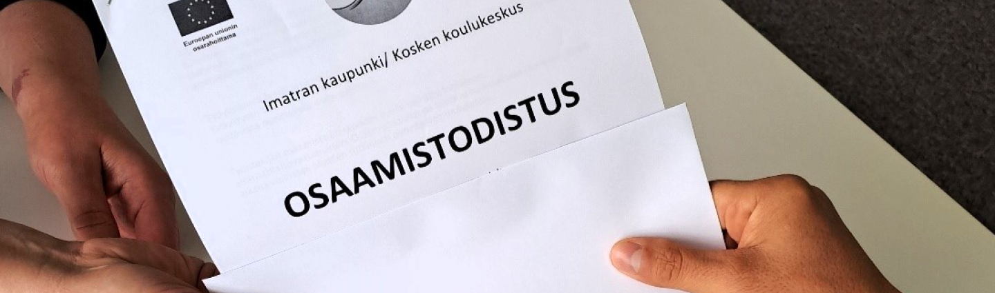 Kahdet kädet pitävät paperia, jossa lukee osaamistodistus.