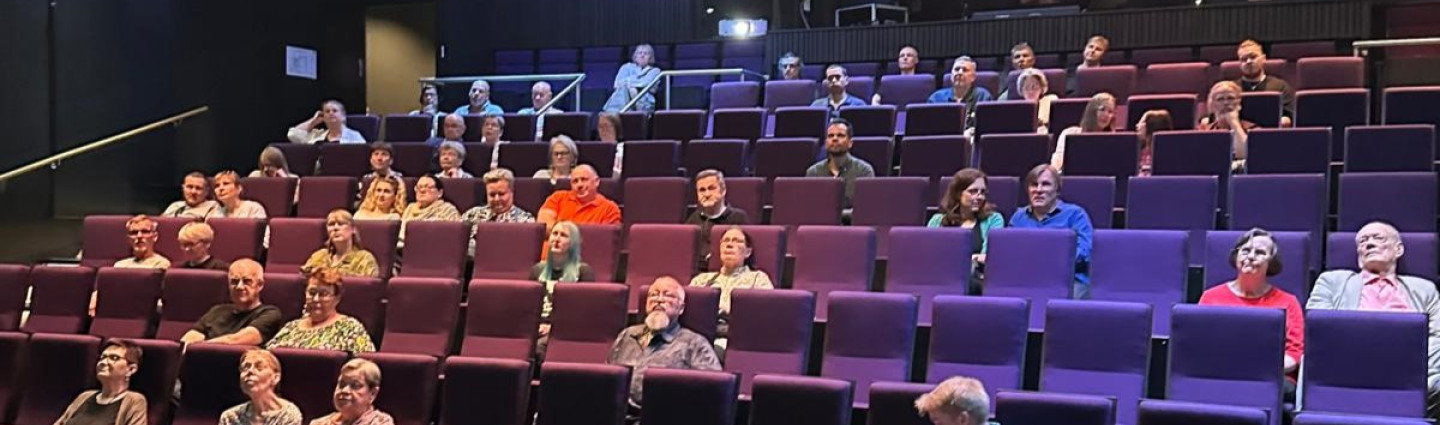 Ihmisiä teatterin katsomossa.