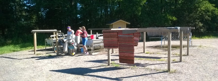 Matonpesupaikka, jossa kolme ihmistä on pesemässä mattoja.