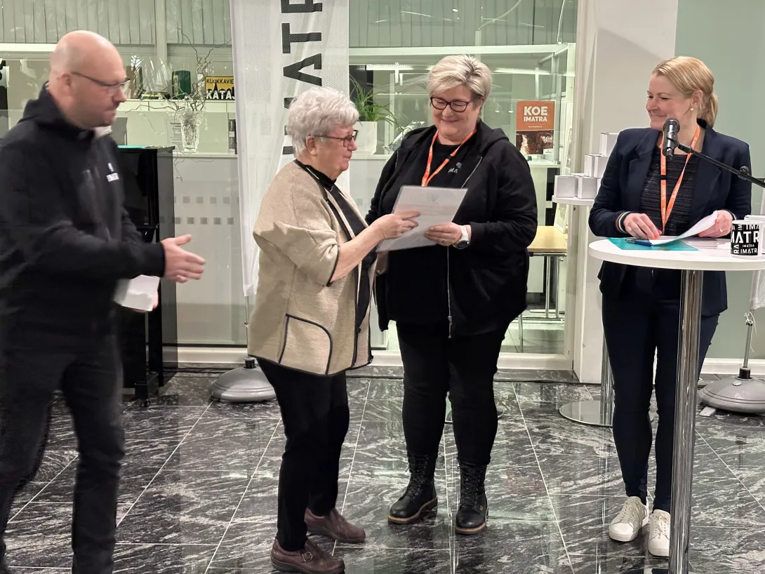 Neljä ihmistä seisomassa hymyillen.