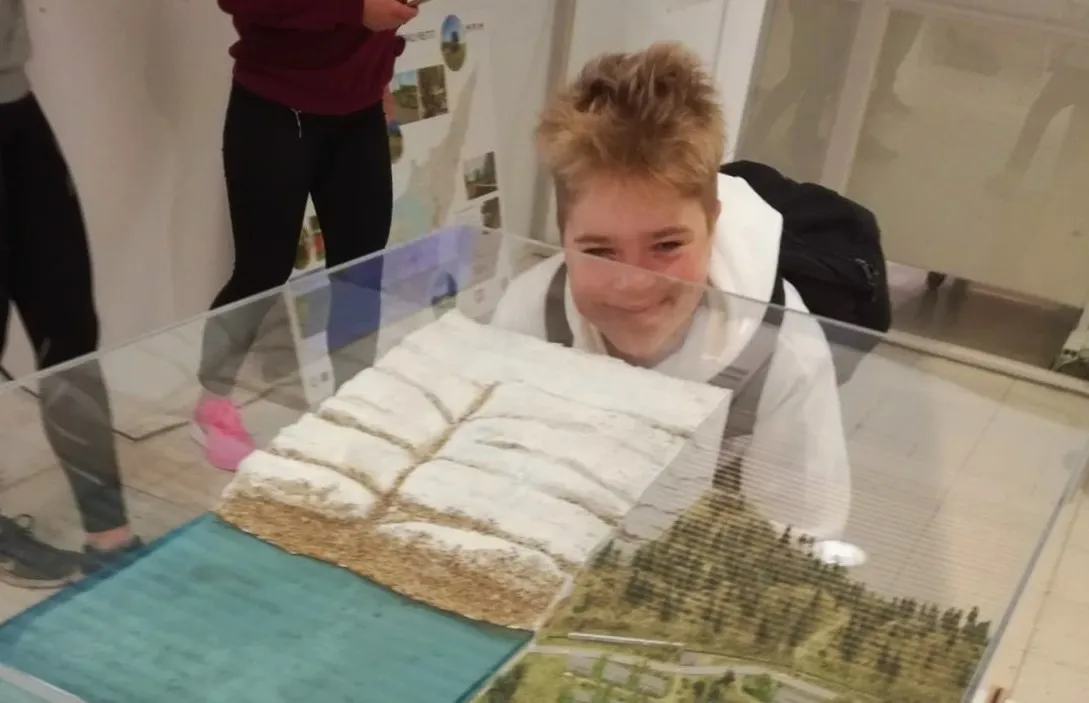 Opiskelija katsoo vitriinissä olevaa jääkausimaisemaa.